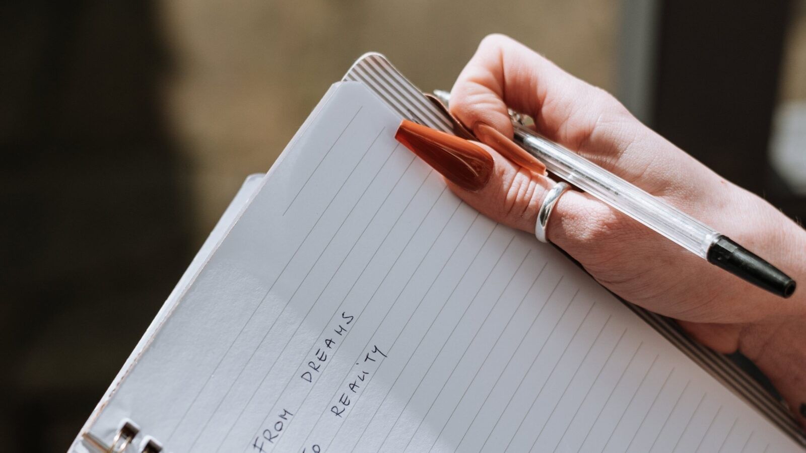 woman holding a pen and a notebook