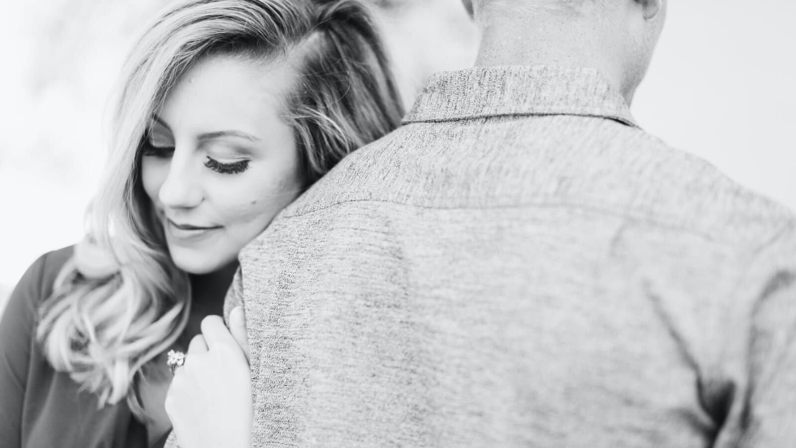 woman with engagement ring holding on to a man