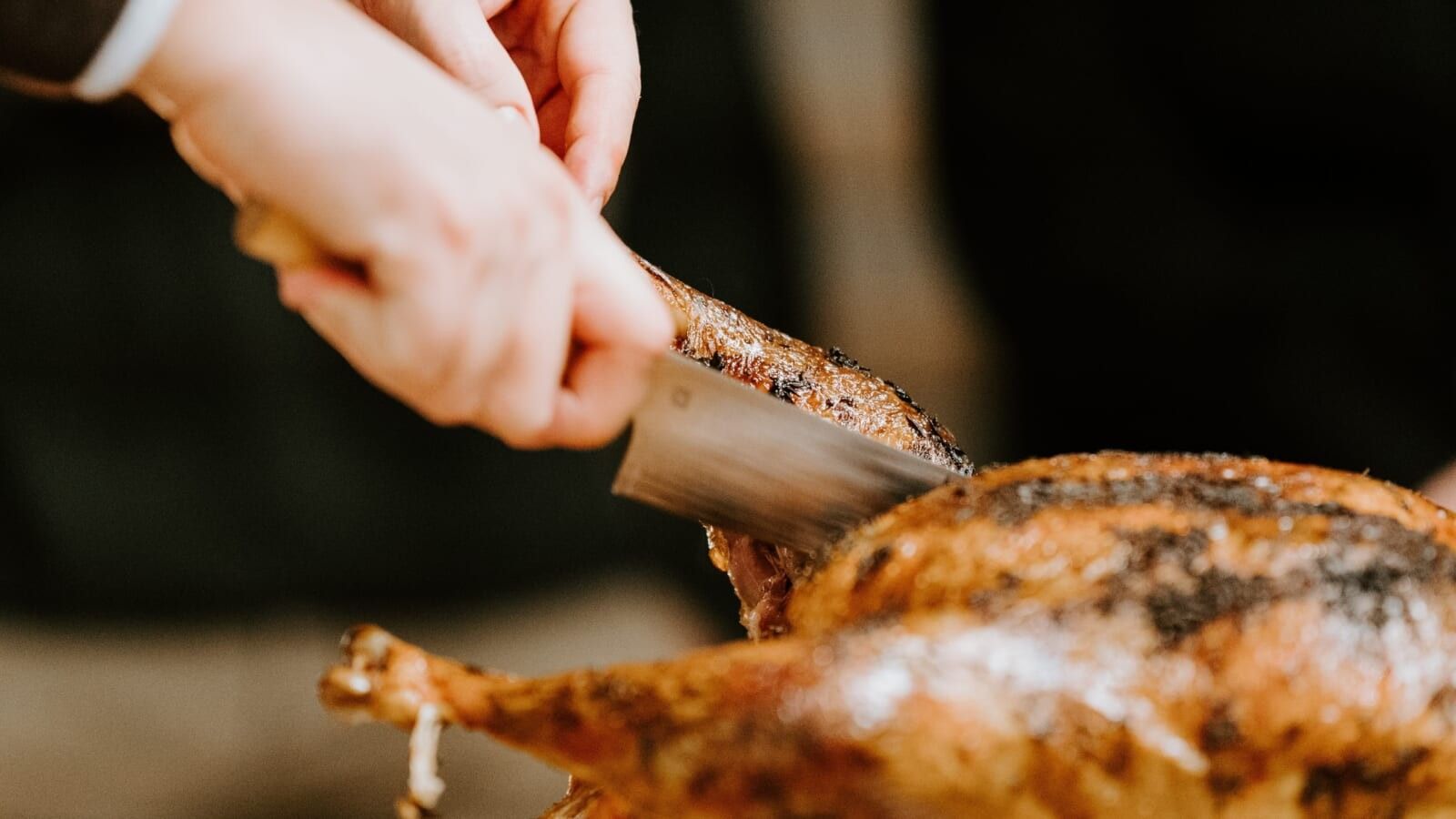 man carving a thanksgiving turkey