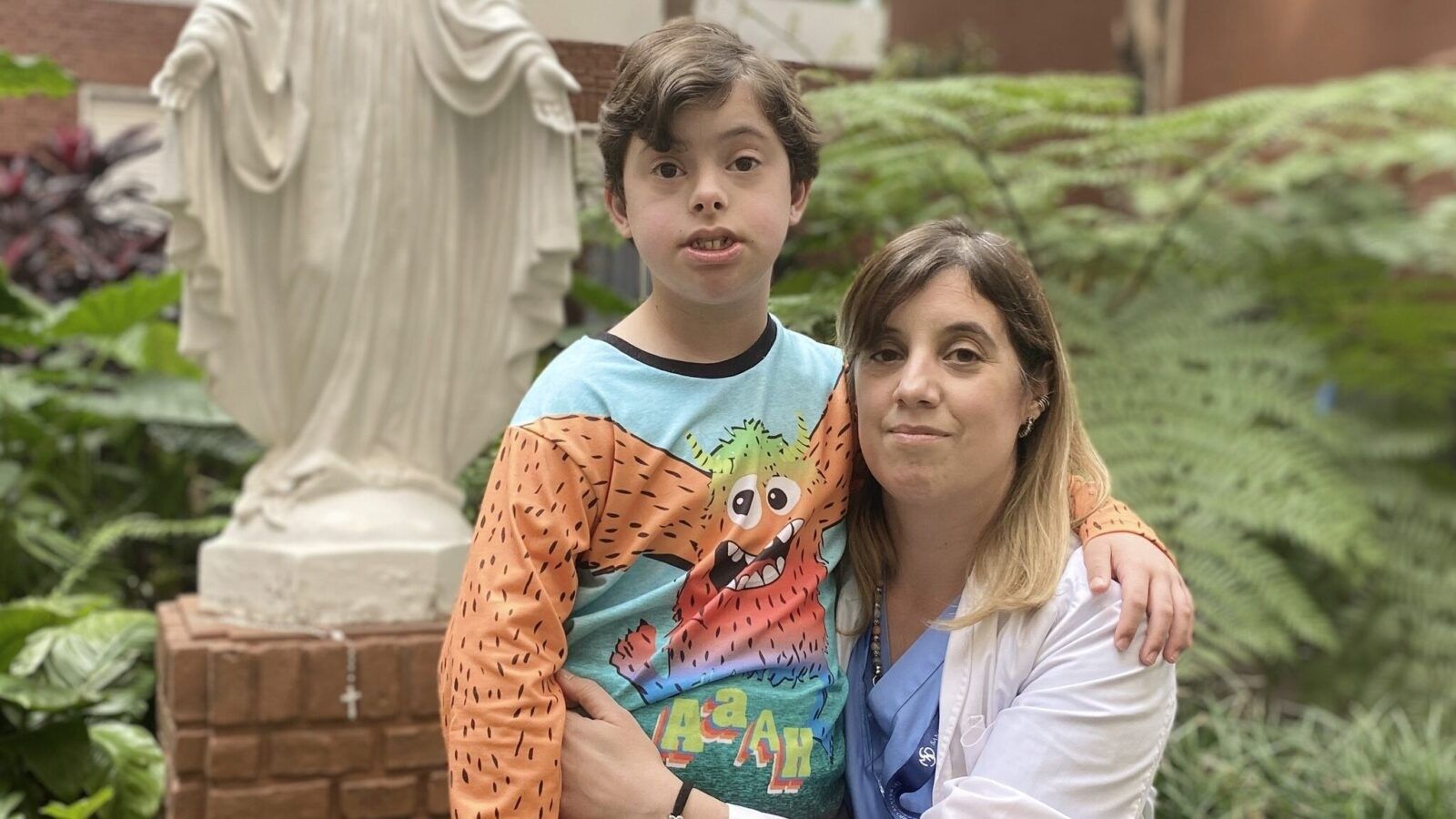pre-teen boy standing next to a crouching woman