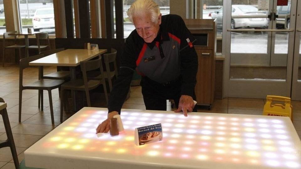 elderly man cleaning a table