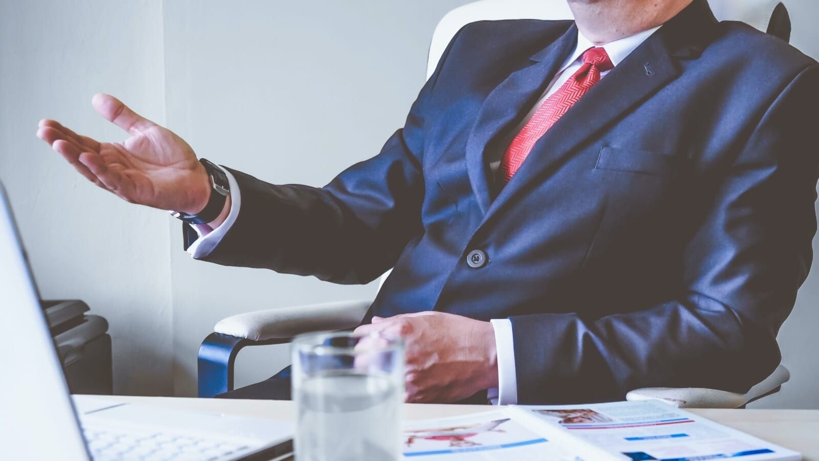 man in a blue suit sitting at a desk