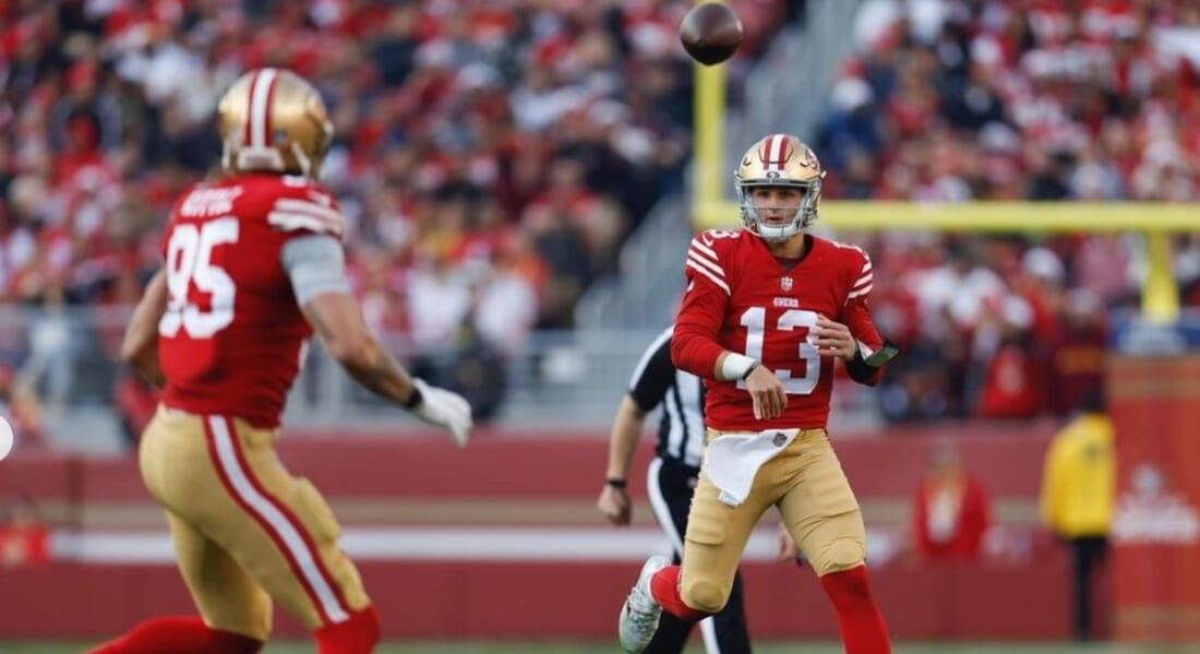 Brock Purdy throwing the football to team mate.