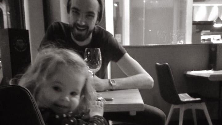 man in a beanie sitting at a table with a little girl