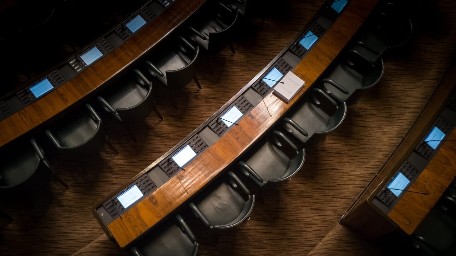 an overview of a room with empty chairs and papers on the table