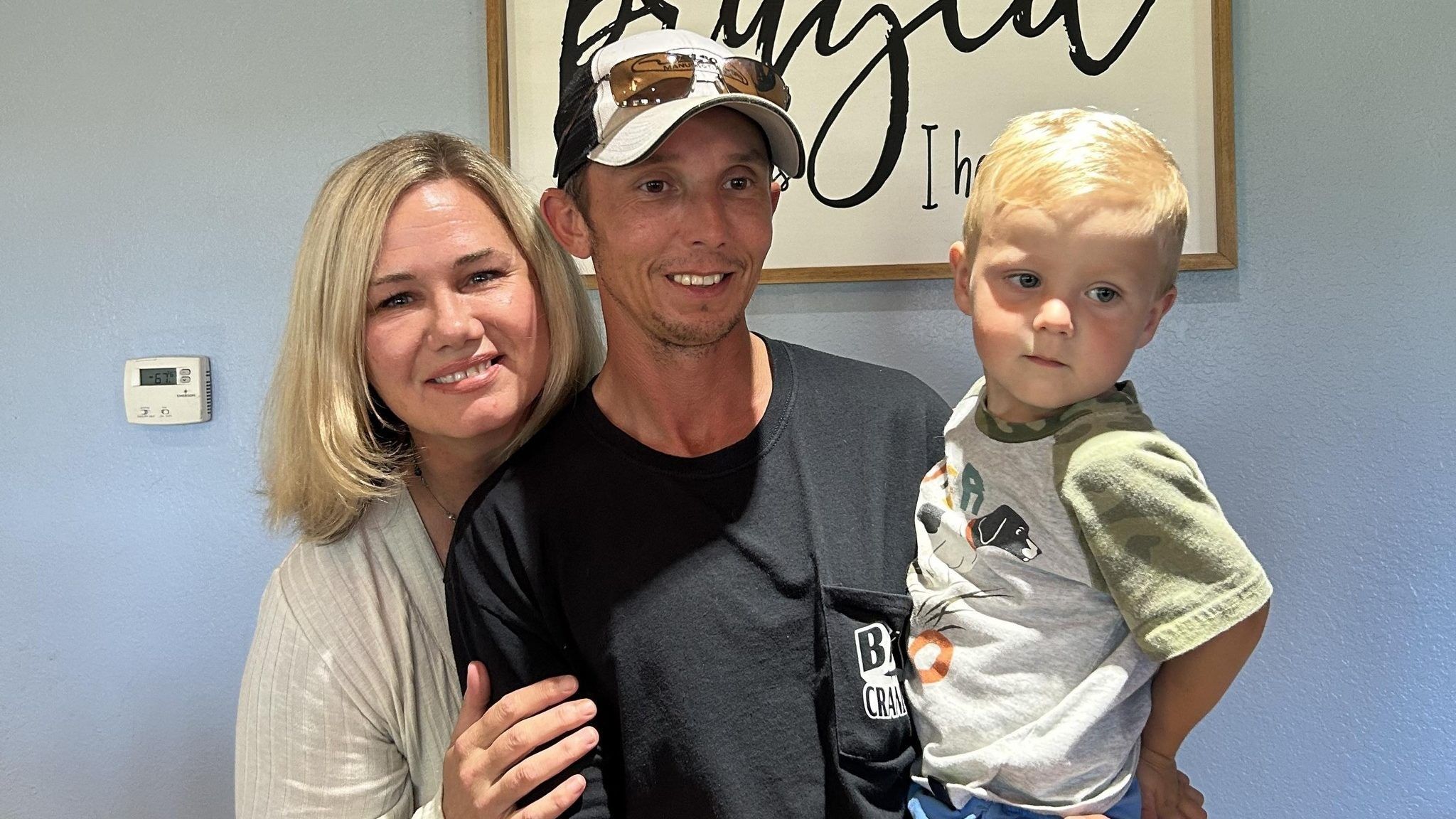 woman and man holding a little boy in their arms