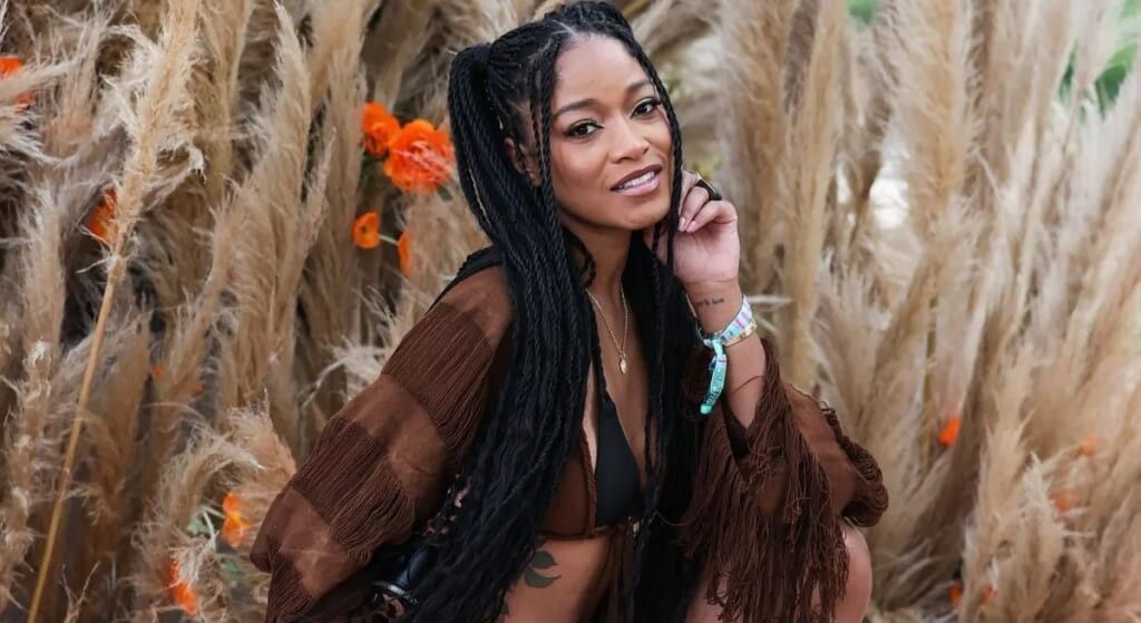 Keke Palmer in a field wearing a brown blouse.