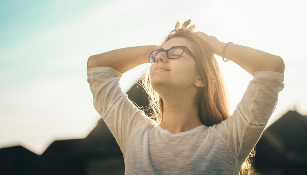 young woman wearing glasses golden hour