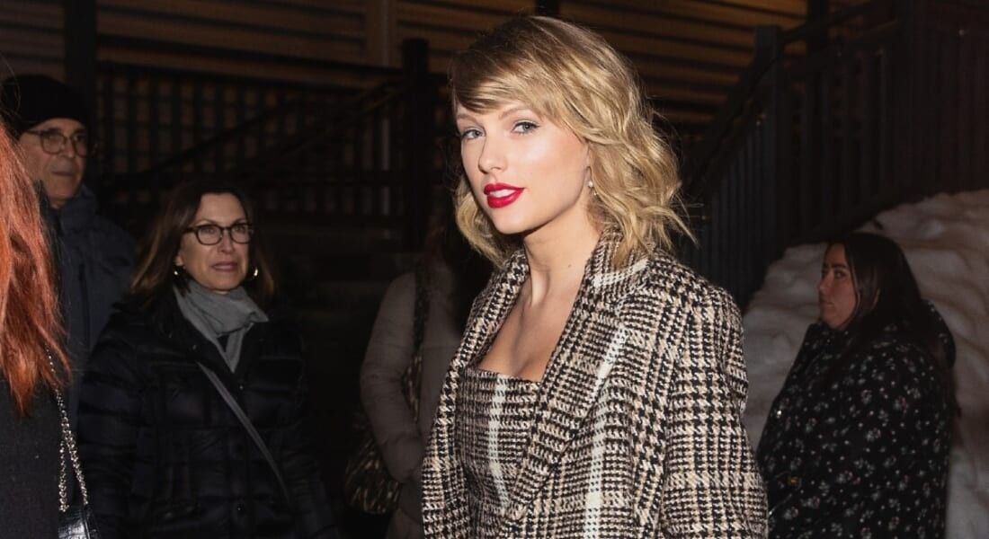 Taylor swift in houndstooth jacket and red lipstick.
