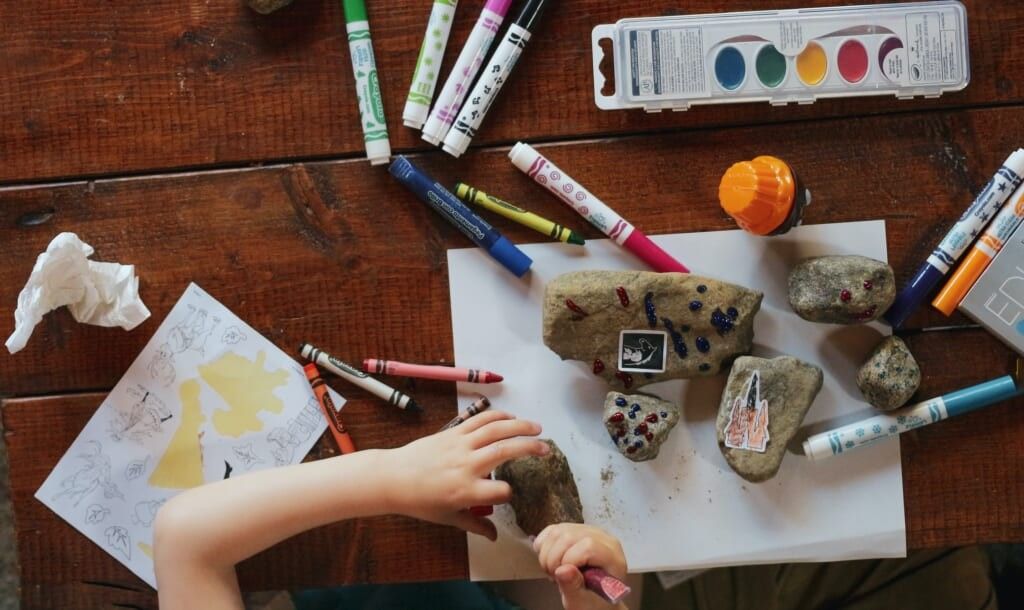 hands working on art markers on table