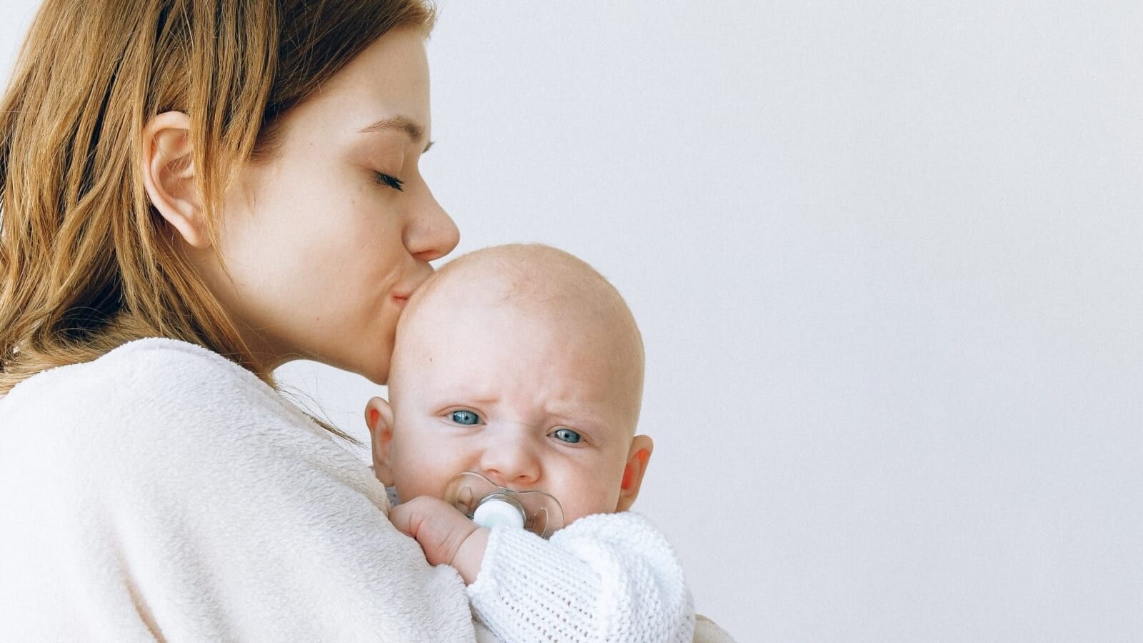 woman kissing her baby