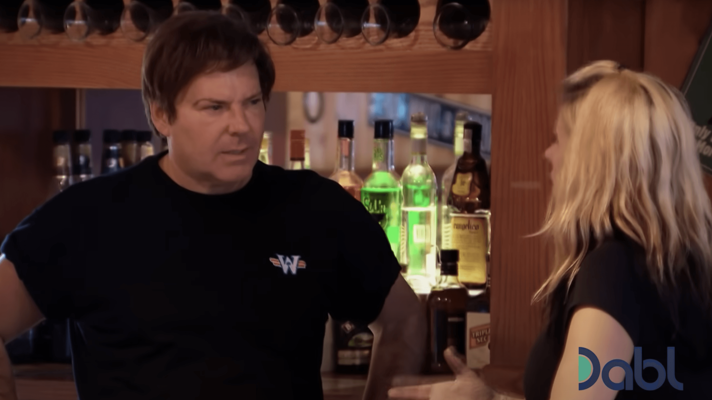 man speaking to a blonde haired woman