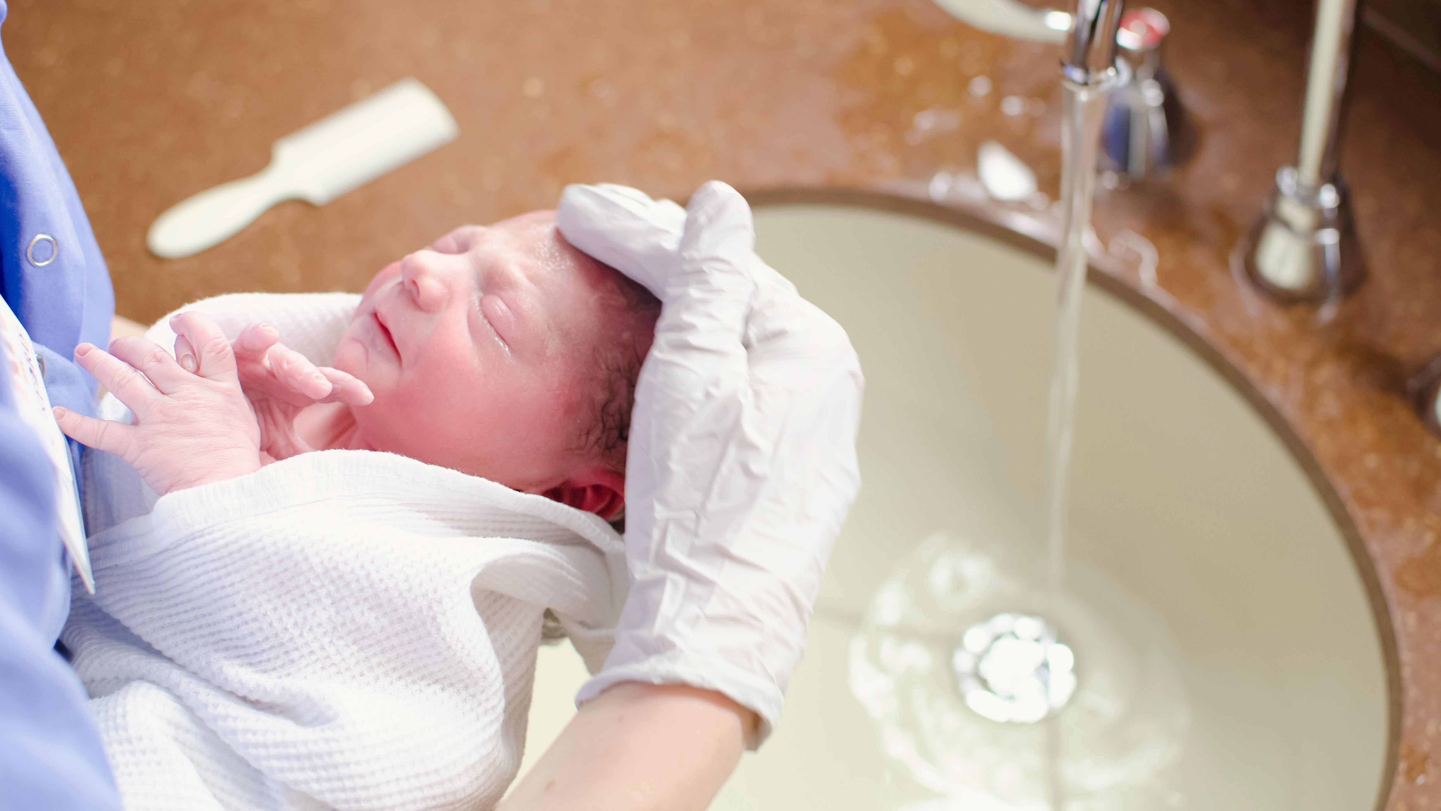 nurse holding a newborn baby