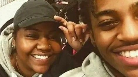 woman wearing a cap and smiling with her son