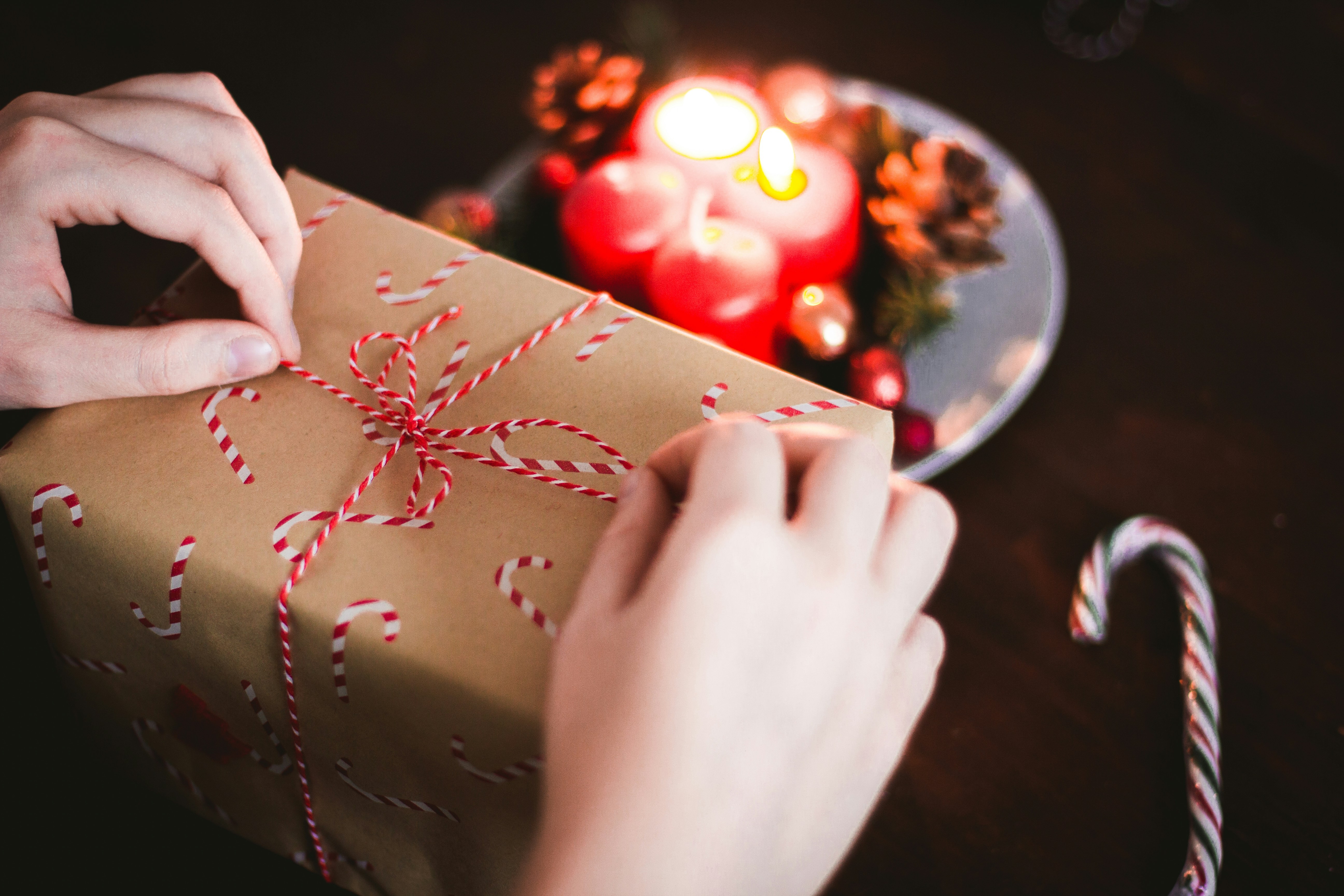 a person tying a bow on a Christmas present